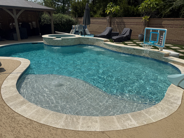 Clean in-ground pool and raised spa kept clear by weekly pool cleaning in Houston, TX